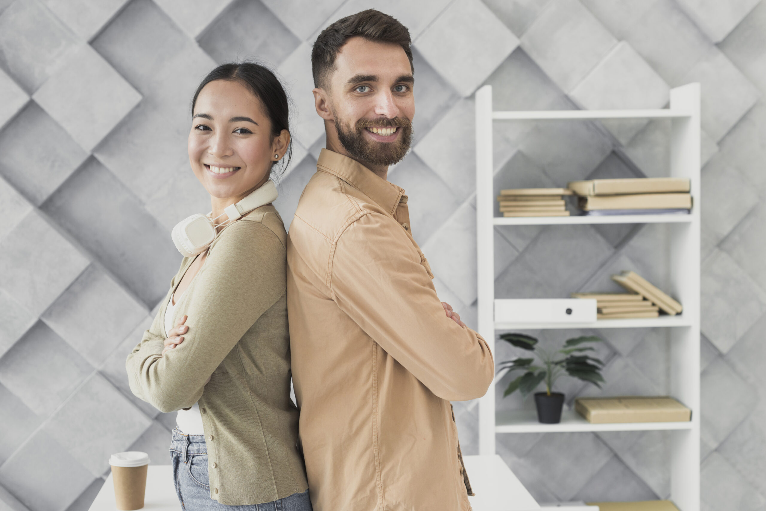 Feature image Homem e mulher, posando de costas um para o outro em um escritório.
