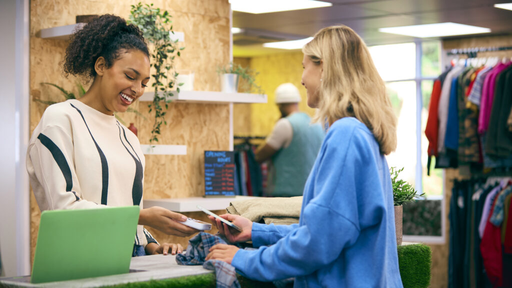  Atendimento em loja de roupas representando a estratégia de cross-sell no balcão para aumentar o ticket médio.