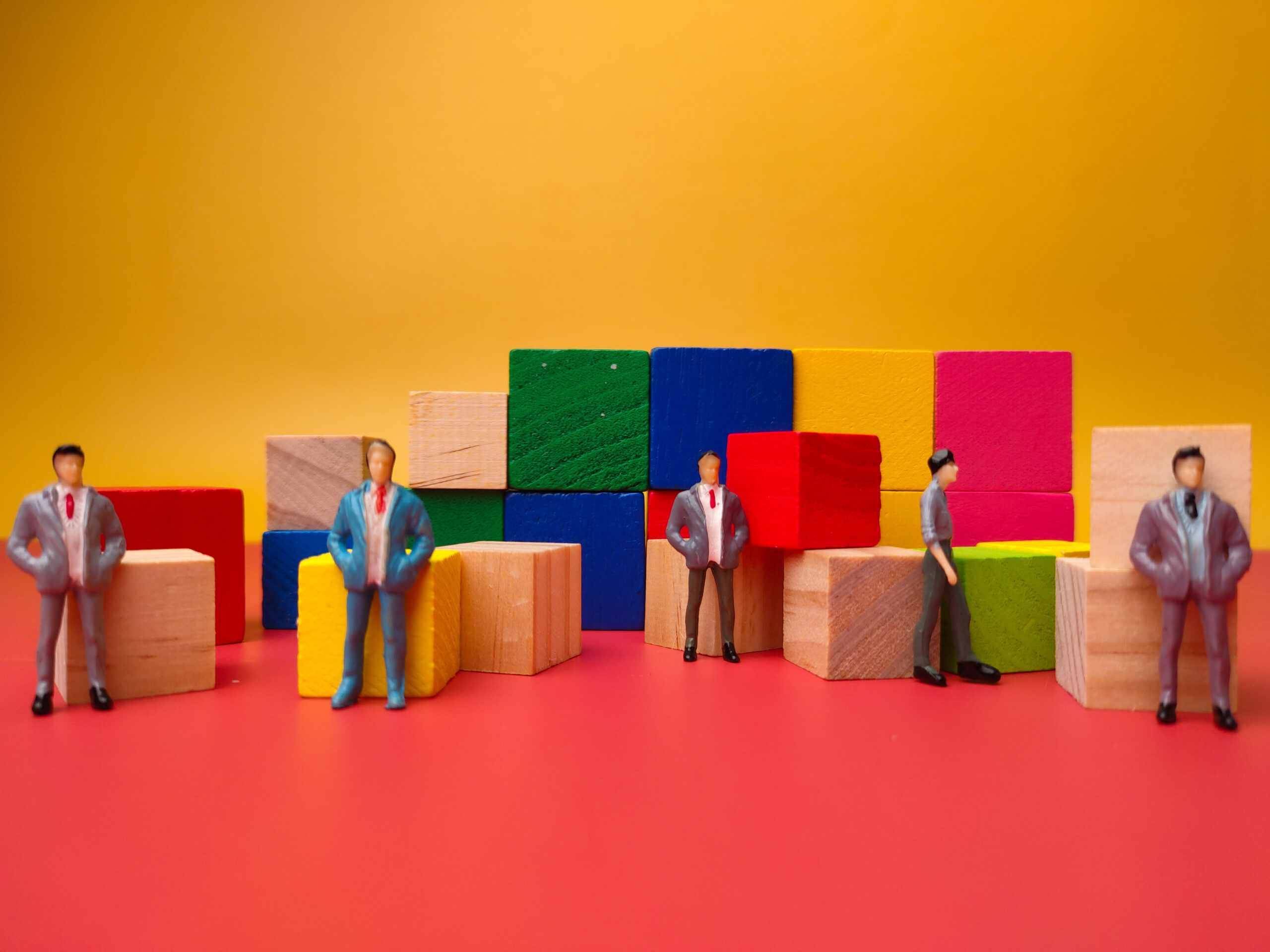 Miniatura de empresários ao redor de blocos coloridos representando negociação B2B entre empresas e ilustrando o conteúdo "B2B: o que é e como funciona esse modelo de negócio